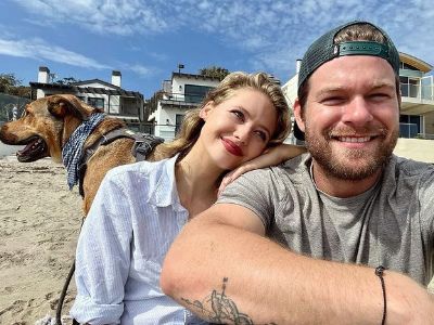 Kassandra Clementi is lying on Dan McKernan shoulder as there is a dog in the background.